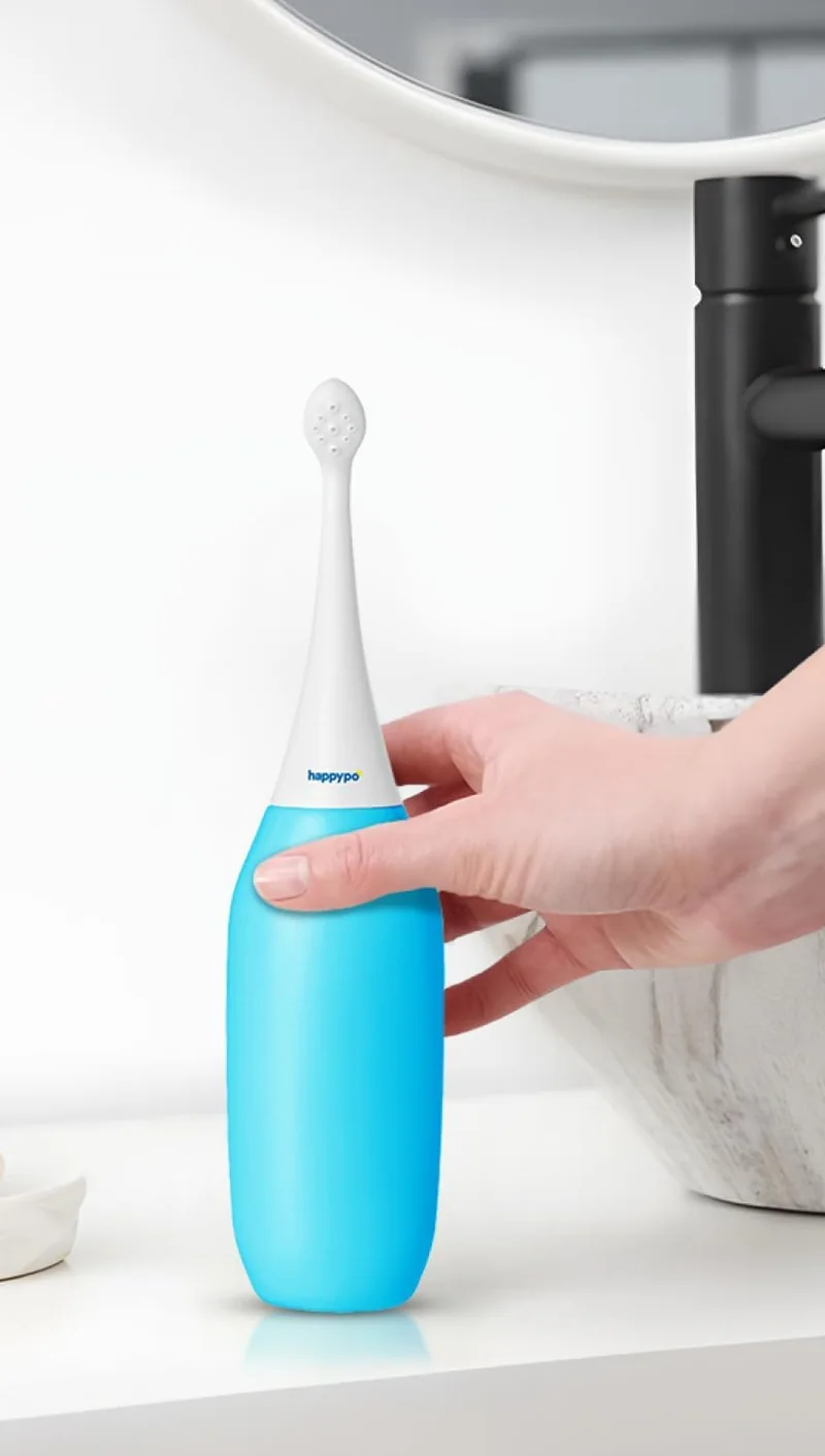 A light blue HappyPo bottle on a bathroom shelf by the sink